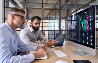 2 office workers reviews data on a screen in front of them